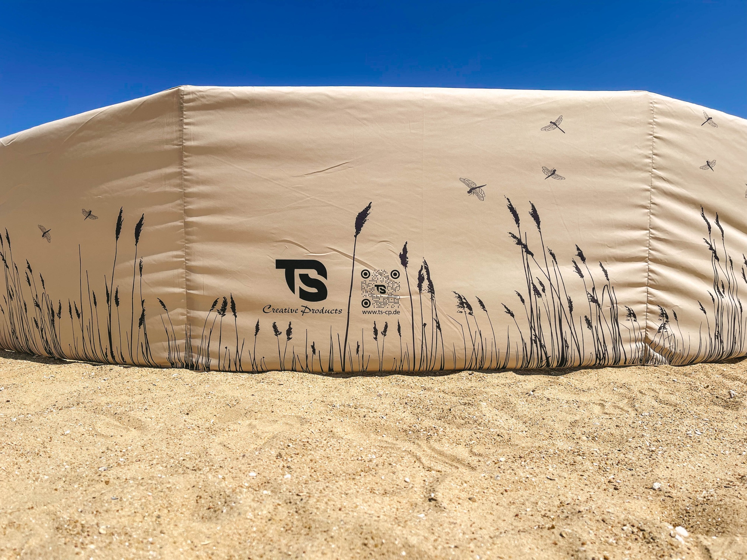 IMG_5605 Windschutz am Strand in Großaufnahme, Farbe Beige mit Schilöfrohrmuster, Logo und QR Code
